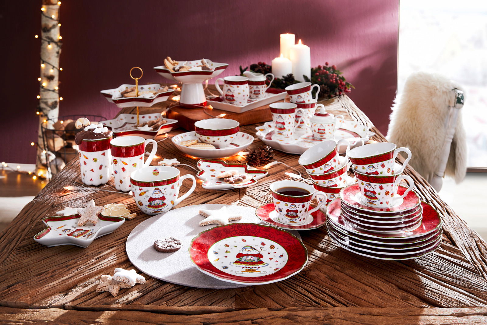 Weihnachtliches Kaffeeservice auf einem Tisch, bestehend aus Tassen, Tellern und Schalen mit festlichem Design, aus der Vogelperspektive fotografiert.