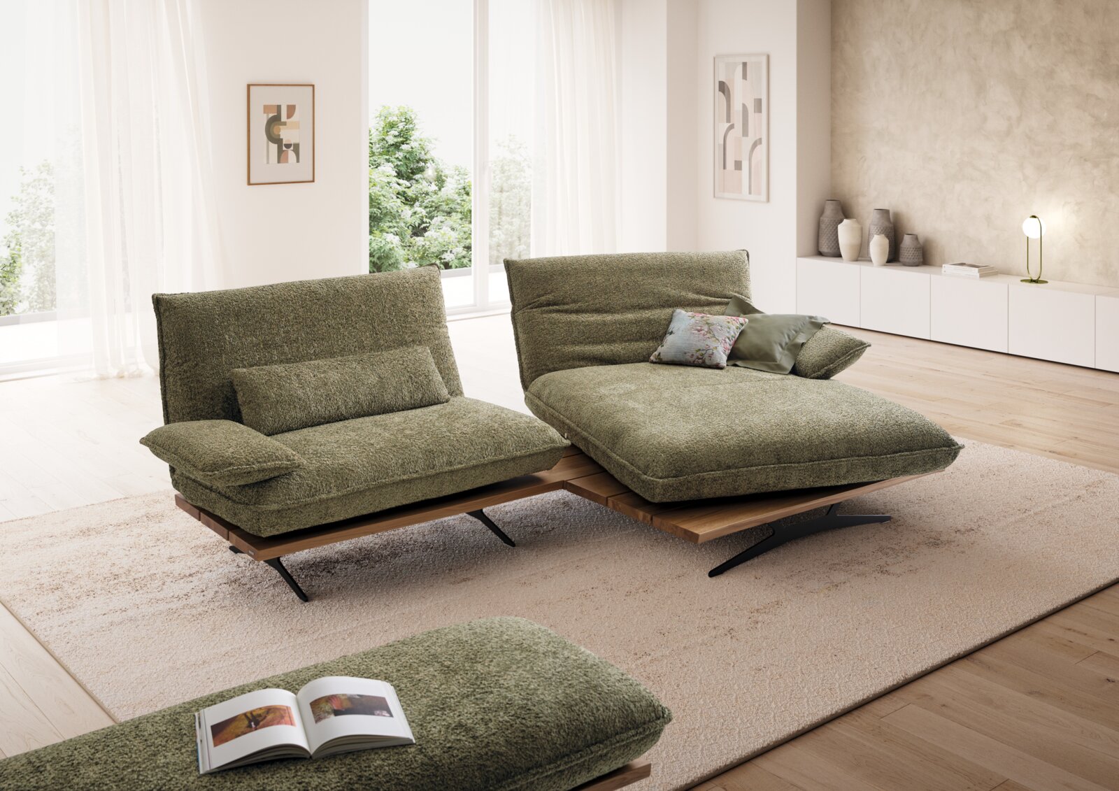 Modernes, modulares Sofa-Set in olivgrünem Stoff mit Holzsockel und schwarzen Metallfüßen im hellen Wohnzimmer, perspektivisch in leichter Schrägansicht von vorne.