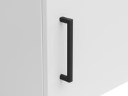 Nahaufnahme eines schwarzen Griffs an einer weißen Schranktür, seitliche Perspektive