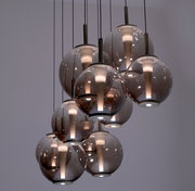 Moderne LED-Pendelleuchte mit mehreren kugelförmigen, rauchgrauen Glaskörpern, von unten betrachtet.