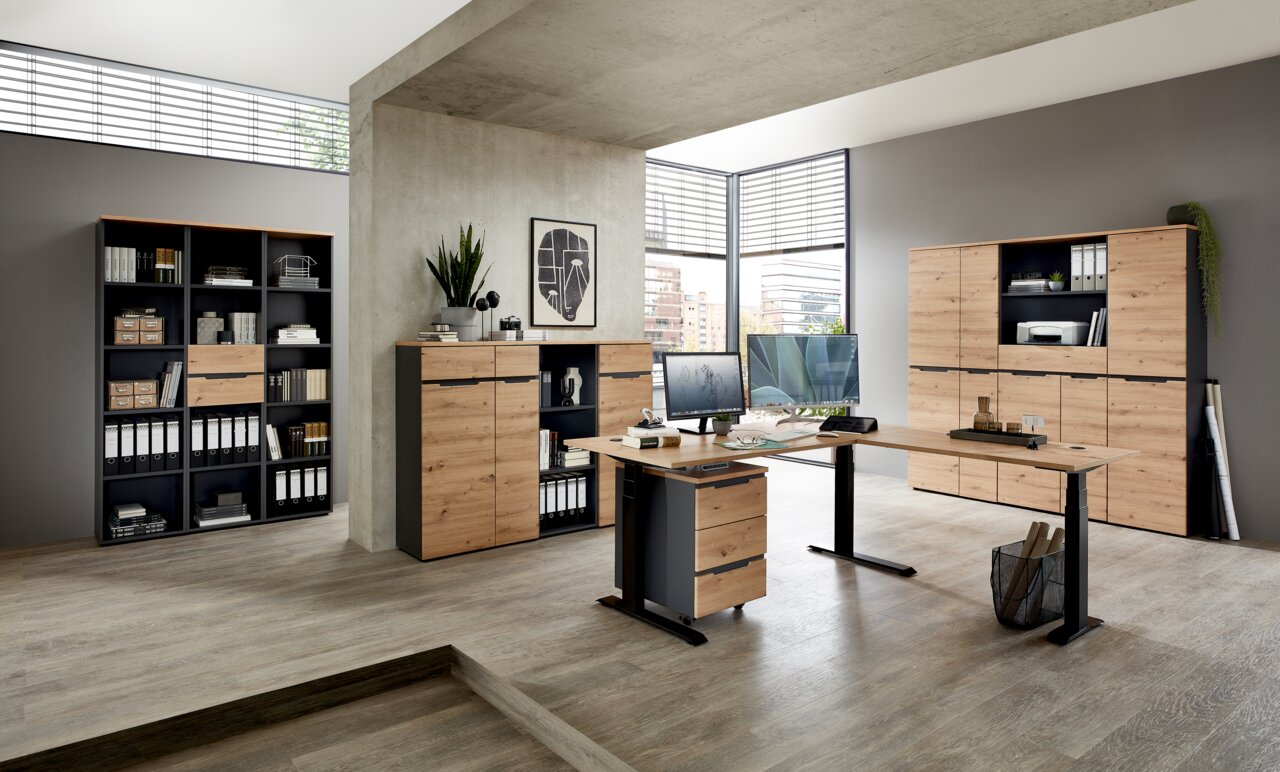 Voleo Regalschrank DETROIT Moderne Büromöbel in einem hellen Raum mit Schreibtisch, Aktenschränken und Regalen in Holzoptik, seitliche Perspektive.