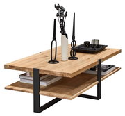 Moderner Couchtisch aus hellem Massivholz mit schwarzem Metallgestell und zusätzlicher Ablage, dekoriert mit Kerzenhaltern, Vase und Tablett, in schräger Frontansicht von oben