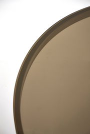 Nahaufnahme eines runden Couchtischs mit einer glatten, braunen Oberfläche, von oben betrachtet.