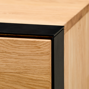 Nahaufnahme eines Sideboards mit Holzoberfläche und schwarzem Metallrahmen, Perspektive von der Ecke