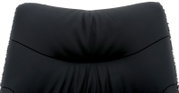 Close-up van de rugleuning van een zwarte leren fauteuil, gezien vanaf de voorkant.