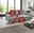 Graues Sofa vor großen Fenstern mit rotem Prozentzeichen – modernes Wohnzimmer im Angebotsdesign