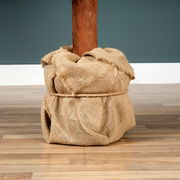 Nahaufnahme des Sockels einer Tiaga Tanne, umwickelt mit Jutestoff, auf einem Holzboden stehend.