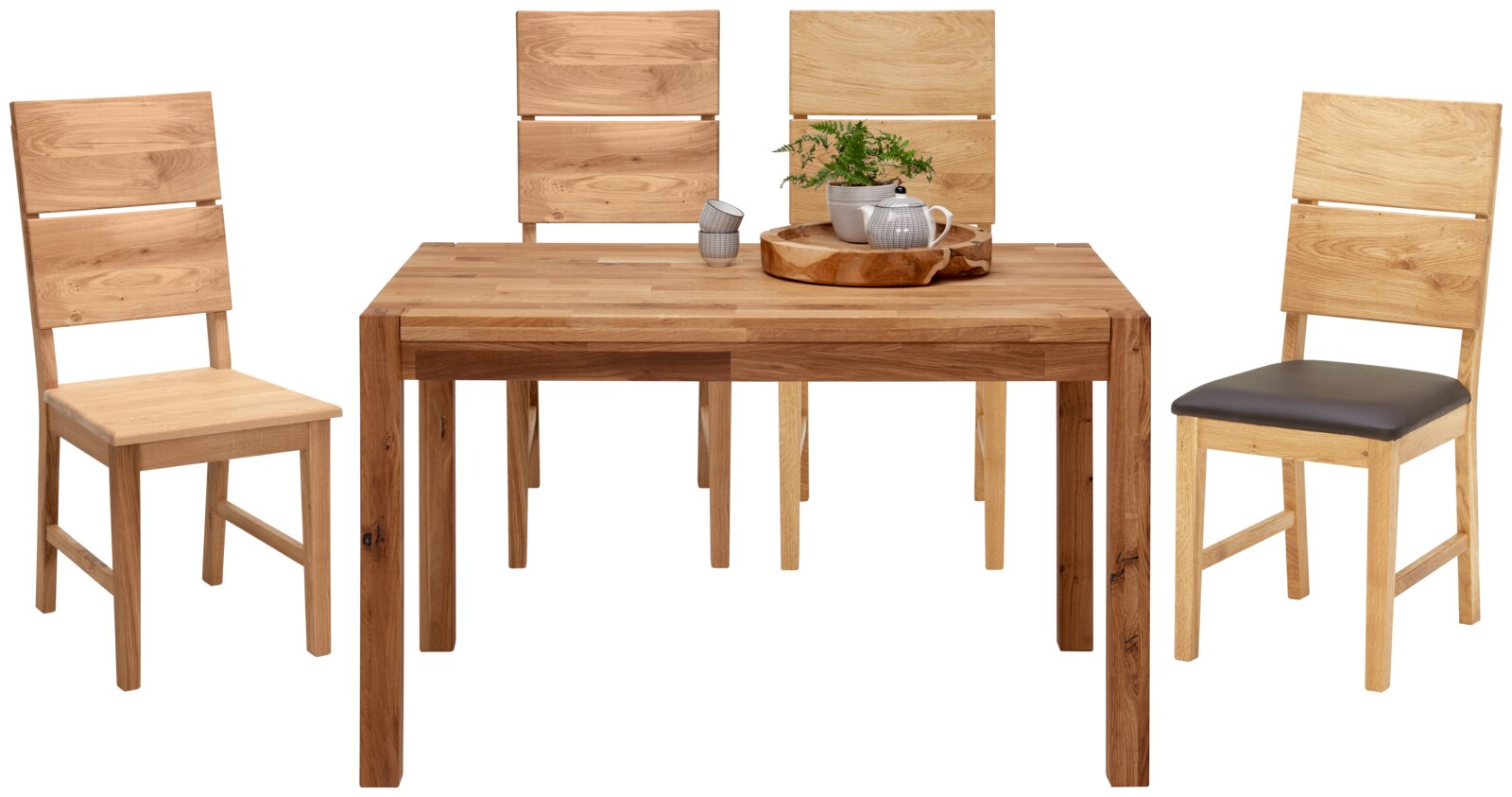 Linea Natura Stuhl ARNOLD Holz-Esstisch mit vier passenden Stühlen, teils mit gepolsterter Sitzfläche, frontal in leichter Schrägansicht von vorn auf weißem Hintergrund; auf dem Tisch Tablett mit Teekanne, Tassen und Pflanze.