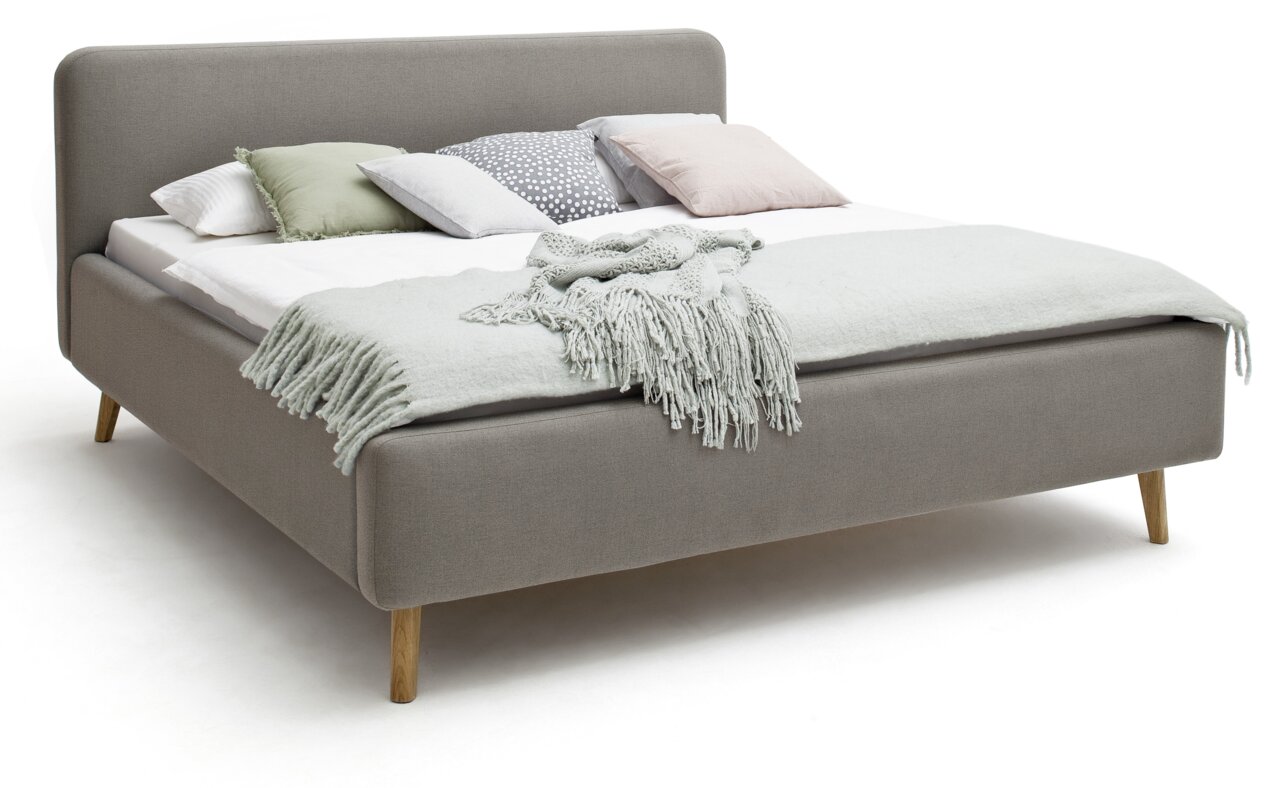Graues Polsterbett mit Holzfüßen, dekoriert mit Kissen und einer Decke, seitliche Perspektive