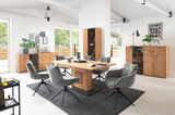 Modernes Wohnzimmer mit einem Sideboard aus Holz, umgeben von einem Esstisch und grauen Stühlen, aus der Perspektive des Raumes betrachtet.