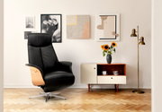 Zwarte relaxfauteuil met houten armleuningen in een stijlvol ingerichte woonkamer, zijaanzicht