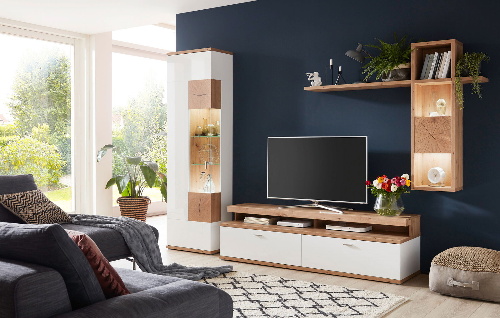 Moderne Wandkombination in einem Wohnzimmer mit TV, Regalen und Dekorationen, seitliche Perspektive
