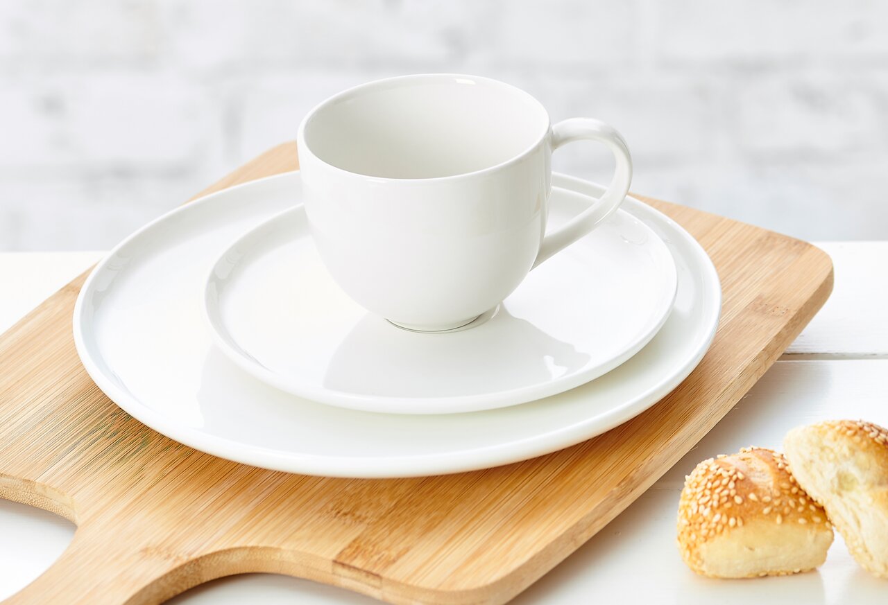 Ritzenhoff & Breker Untertasse SKAGEN Weiße Untertasse Skagen 16cm mit passender Tasse, auf einem Holzbrett präsentiert, seitliche Perspektive.