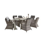 Gartensessel-Set aus grauem Rattan mit Tisch, seitliche Perspektive, dekoriert mit Geschirr und Decken.