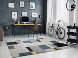 Moderner Teppich mit geometrischem Muster in einem stilvollen Arbeitszimmer, seitliche Perspektive.