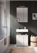 Moderne Badkombination mit weißem Waschbecken und Unterschrank, Spiegel mit Beleuchtung, seitlicher Duschbereich und dekorative Elemente, Frontalansicht.