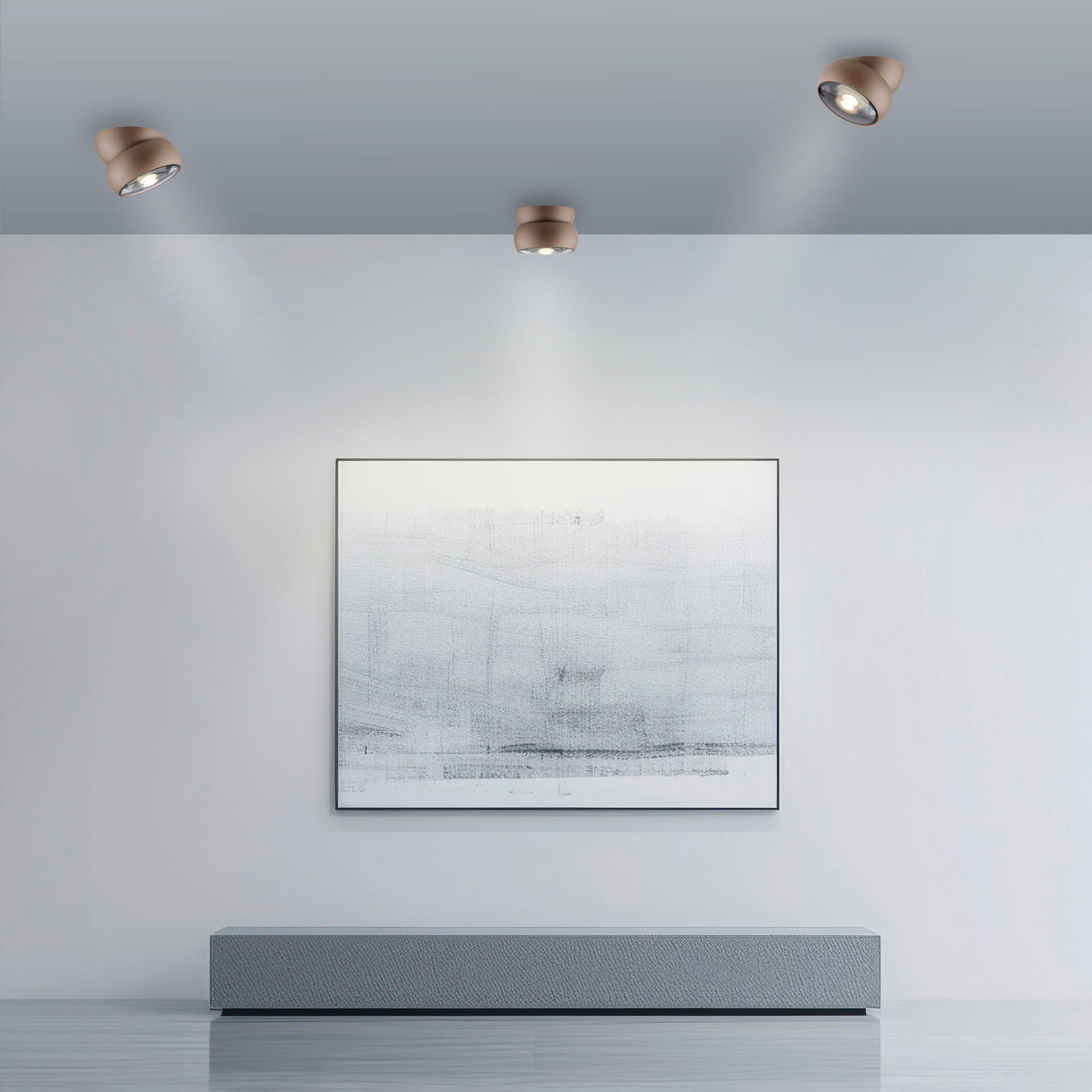 Moderne LED-Deckenleuchte in einem minimalistischen Raum, von unten betrachtet, mit drei Strahlern, die ein Kunstwerk an der Wand beleuchten.