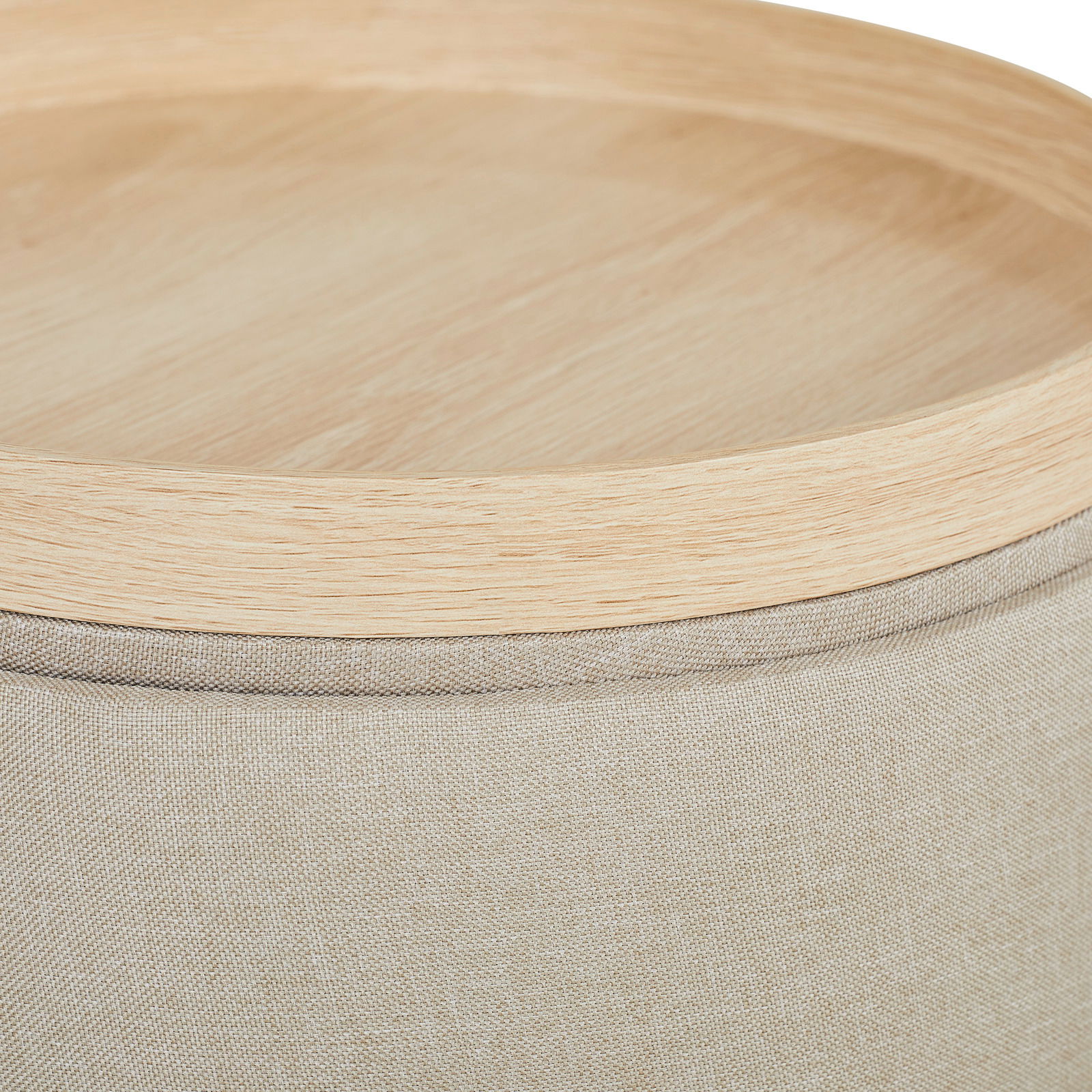 Nahaufnahme eines Hockers mit hellem Holzdeckel und beigem Stoffbezug, von oben betrachtet.
