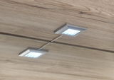 Zwei quadratische LED-Leuchten in einem Holzschrank, von unten betrachtet.