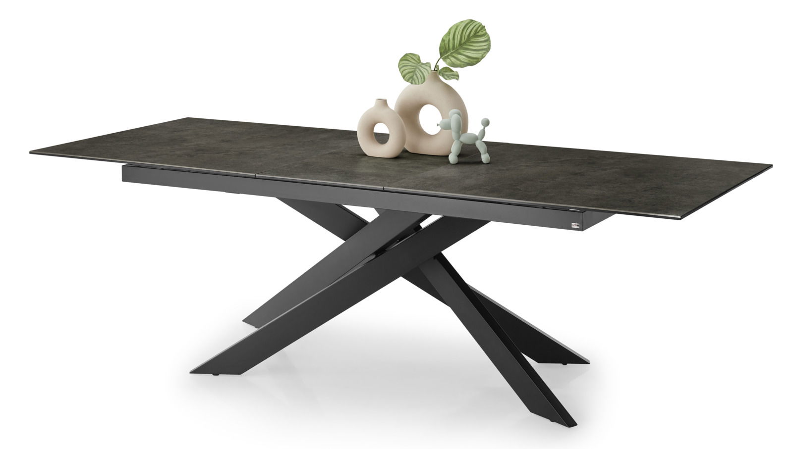 Moderner Esstisch mit dunkler Tischplatte und skulpturalem, überkreuztem Gestell, seitliche Perspektive