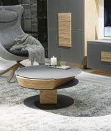 Moderner Couchtisch mit runder, grauer Tischplatte und Holzdetails, seitliche Perspektive