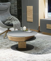 Moderner Couchtisch mit runder, grauer Tischplatte und Holzdetails, seitliche Perspektive