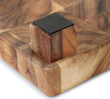 Nahaufnahme eines Hackblocks aus Akazienholz mit Stirnholzdesign, perspektivisch von der Ecke mit einem rutschfesten Fuß gesehen.