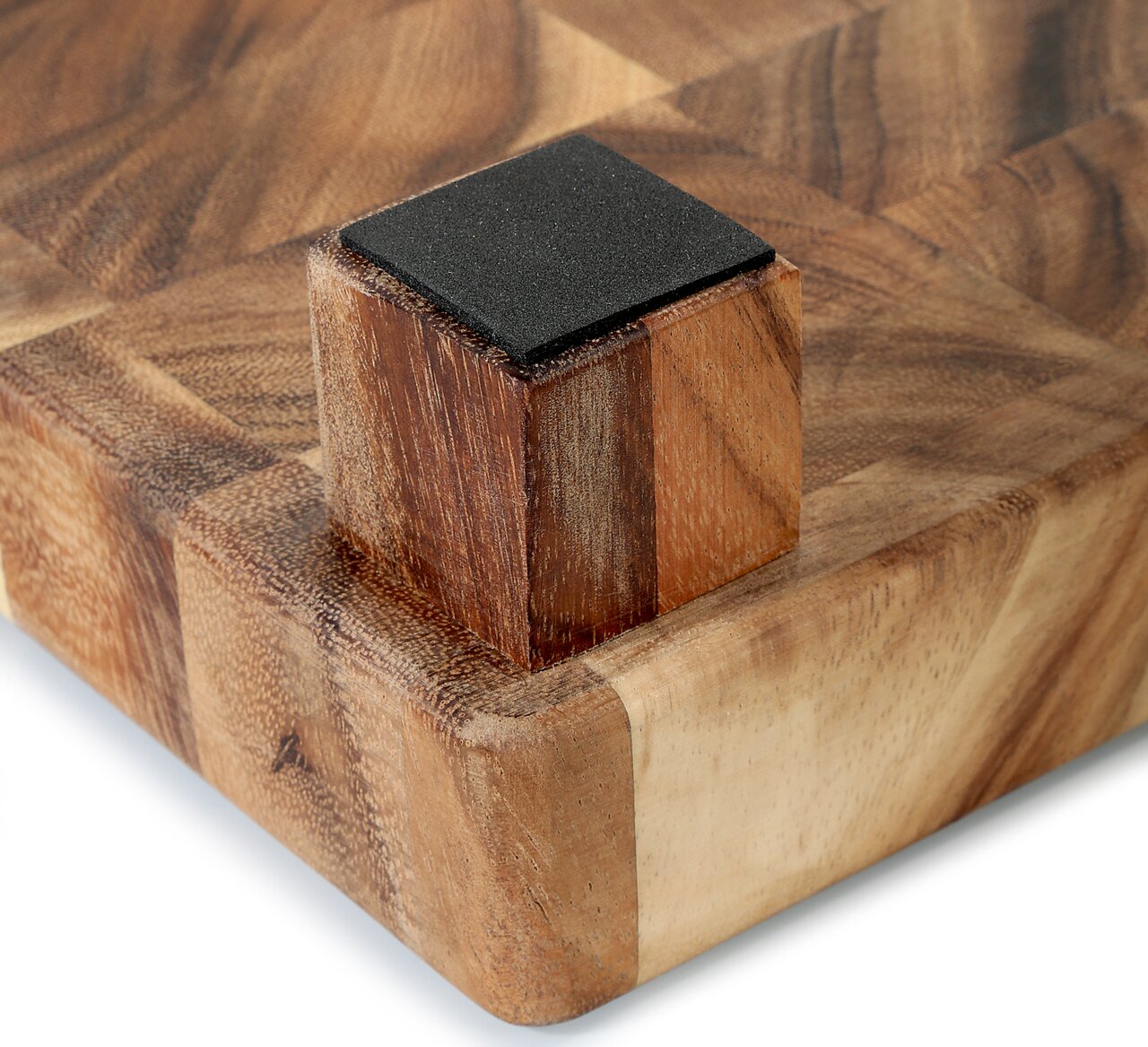 Nahaufnahme eines Hackblocks aus Akazienholz mit Stirnholzdesign, perspektivisch von der Ecke mit einem rutschfesten Fuß gesehen.
