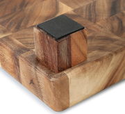 Nahaufnahme eines Hackblocks aus Akazienholz mit Stirnholzdesign, perspektivisch von der Ecke mit einem rutschfesten Fuß gesehen.