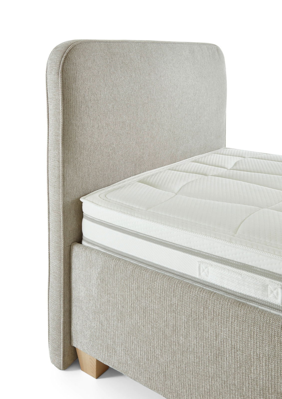 Seitliche Ansicht eines Polsterbetts mit beigem Stoffbezug und sichtbarem Kopfteil.