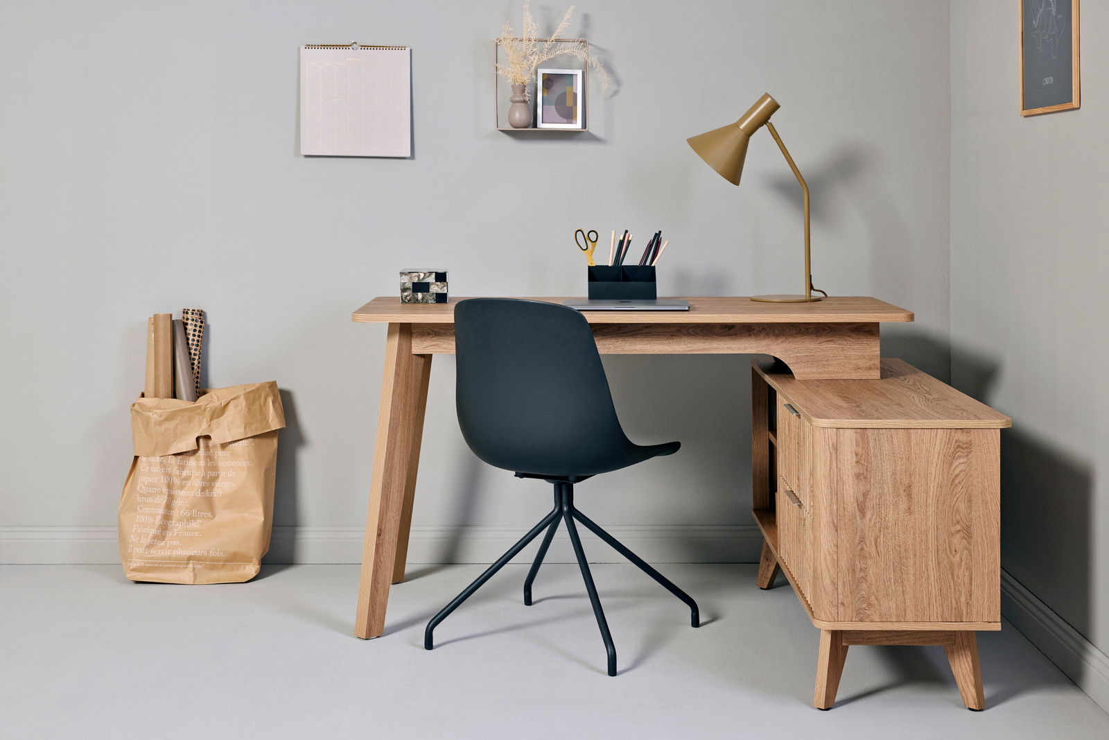 Moderner Eck-Schreibtisch aus Holz mit Stauraum, schwarzem Stuhl und Schreibtischlampe, aus der Perspektive von vorne.