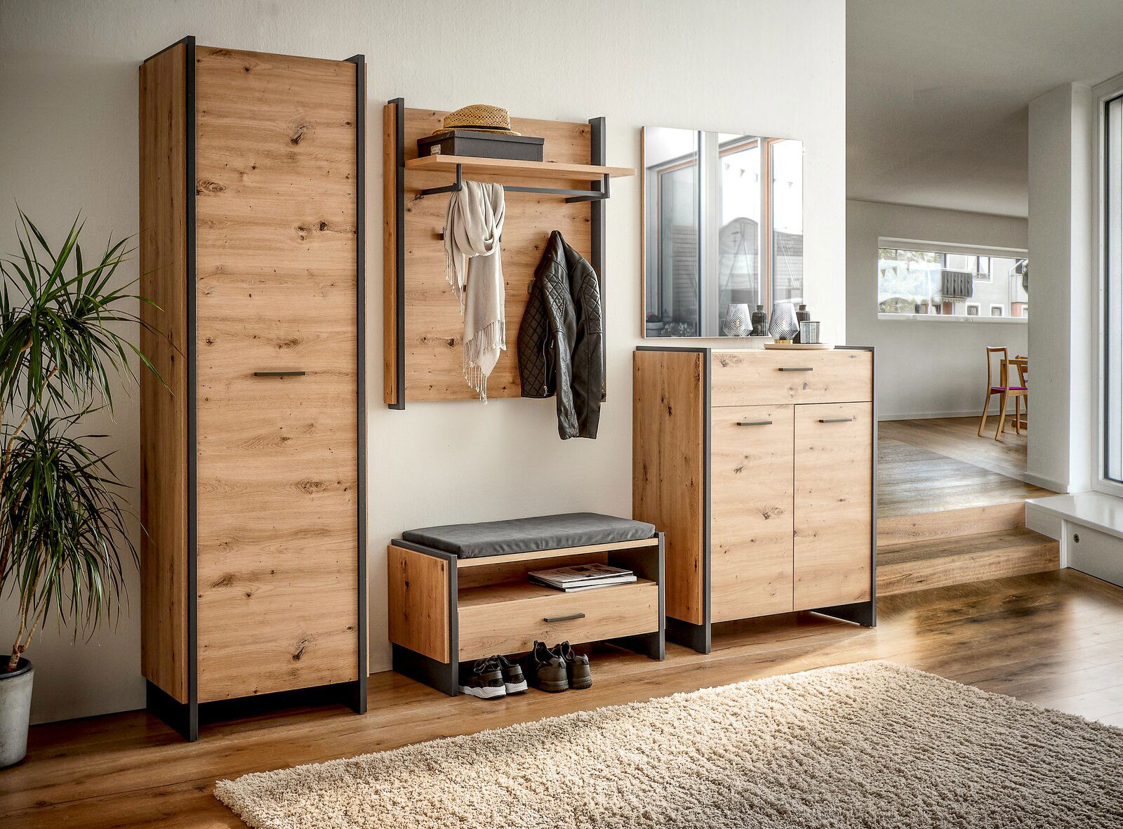 Moderne Garderobenkombination aus Holz mit Schrank, Sitzbank, Paneel und Spiegel in einem hellen Raum, seitliche Perspektive