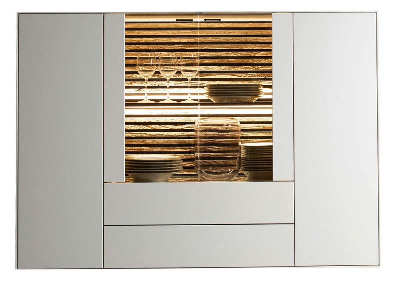 Frontale Ansicht eines modernen Highboards mit beleuchtetem Glaseinsatz, gefüllt mit Geschirr und Gläsern.