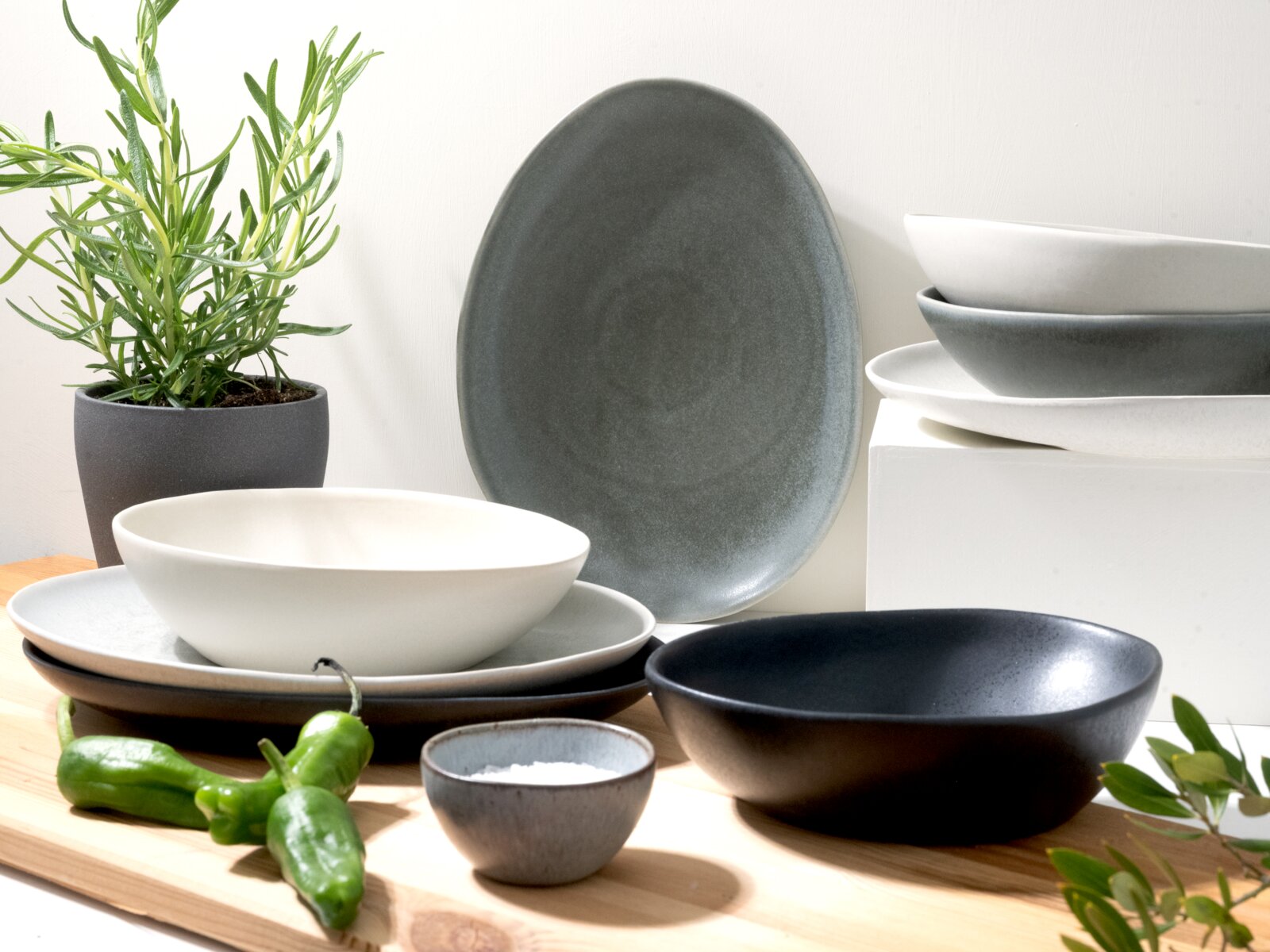 Creatable Tafelservice 8-tlg PIETRA Modernes Keramikgeschirr-Set in Weiß und Grau mit Schalen und Tellern auf Holzbrett, seitliche Frontansicht mit leicht erhöhter Perspektive