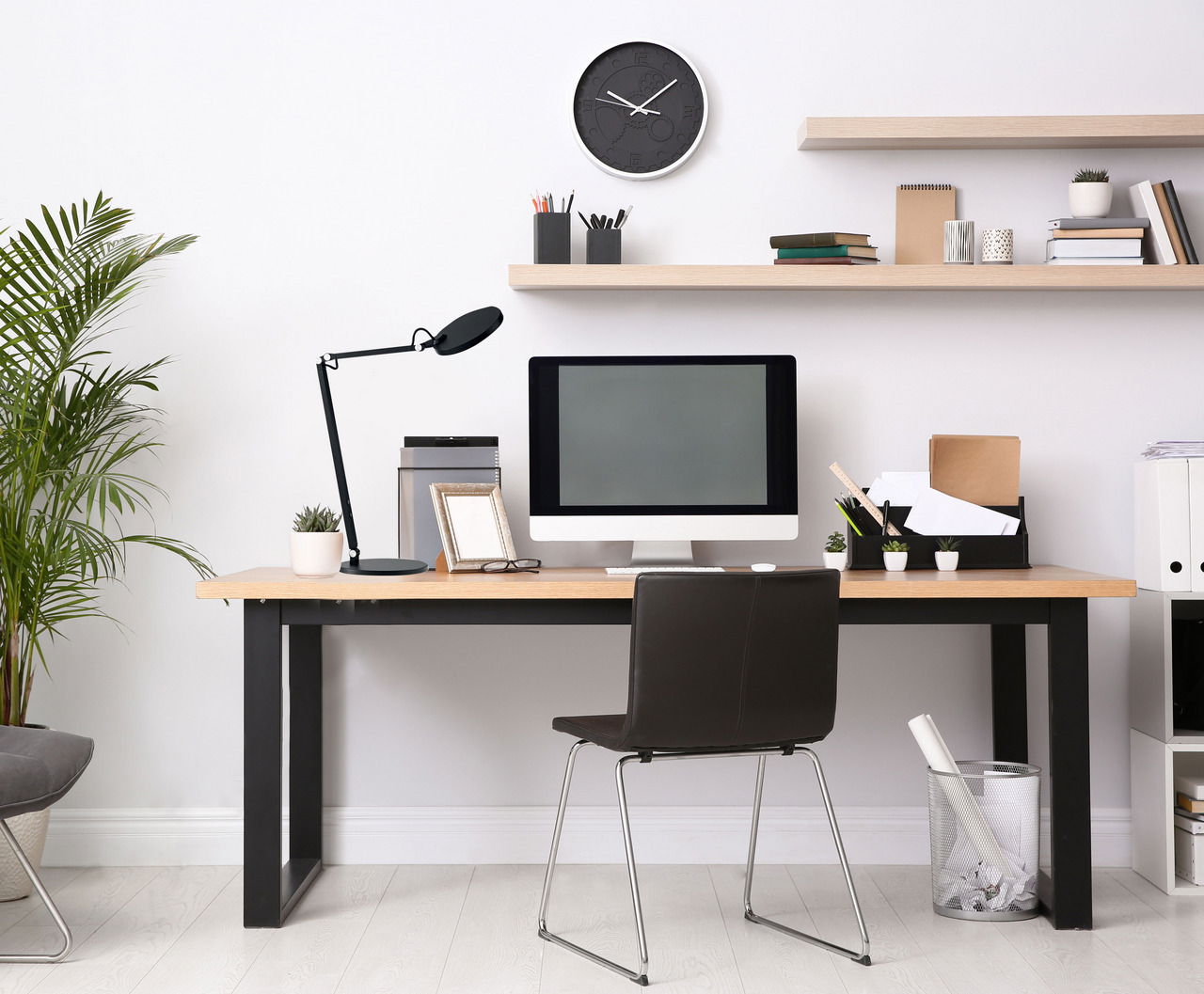 Schwarze Tischleuchte Regina auf einem modernen Schreibtisch, seitliche Perspektive