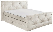Boxspringbett in hellem Stoffbezug mit gestepptem Kopf- und Fußteil, seitliche Perspektive