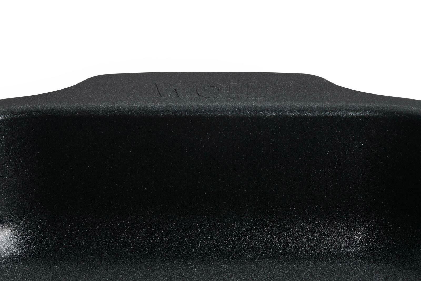 Nahaufnahme einer schwarzen Bratreine mit dem Schriftzug 'WOLL' auf der Oberseite, von vorne betrachtet.