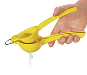 Gelbe Zitronenpresse LIMONA in der Hand gehalten, seitliche Perspektive, mit herausfließendem Zitronensaft.