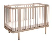 Beiges Babybett aus Holz mit Rundstäben und Matratze, freigestellt vor weißem Hintergrund, Ansicht schräg von vorne (3/4-Perspektive).
