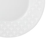 Nahaufnahme eines weißen Frühstückstellers mit dezentem Muster am Rand, von oben fotografiert.