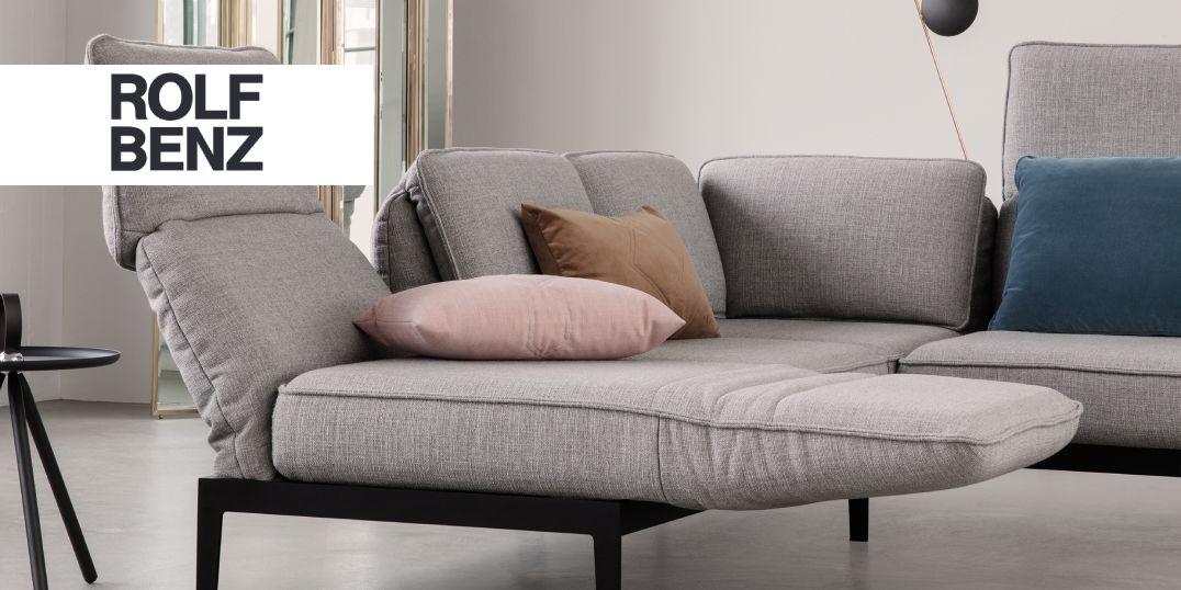 Das Bild zeigt ein graues Designer-Sofa mit Kissen.