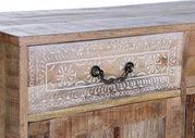 Nahaufnahme einer Holzkommode mit dekorativen weißen Mustern und einem antiken Metallgriff, seitliche Perspektive.