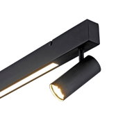 Schwarze, moderne Deckenleuchte mit linearer LED-Lichtleiste und zylindrischem Spot, eingeschaltet; Perspektive: Nahaufnahme von unten in schräger Ansicht.