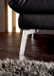 Nahaufnahme eines schwarzen Ledersofas mit verchromtem Metallfuß, seitliche Perspektive.