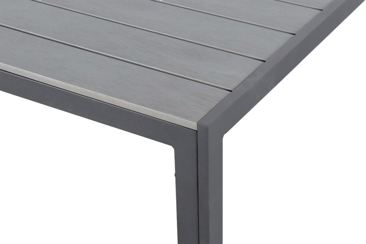 Nahaufnahme eines Gartentisches mit grauer Tischplatte und Metallrahmen, Perspektive von der Ecke.