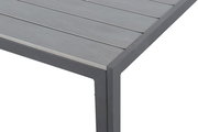 Nahaufnahme eines Gartentisches mit grauer Tischplatte und Metallrahmen, Perspektive von der Ecke.