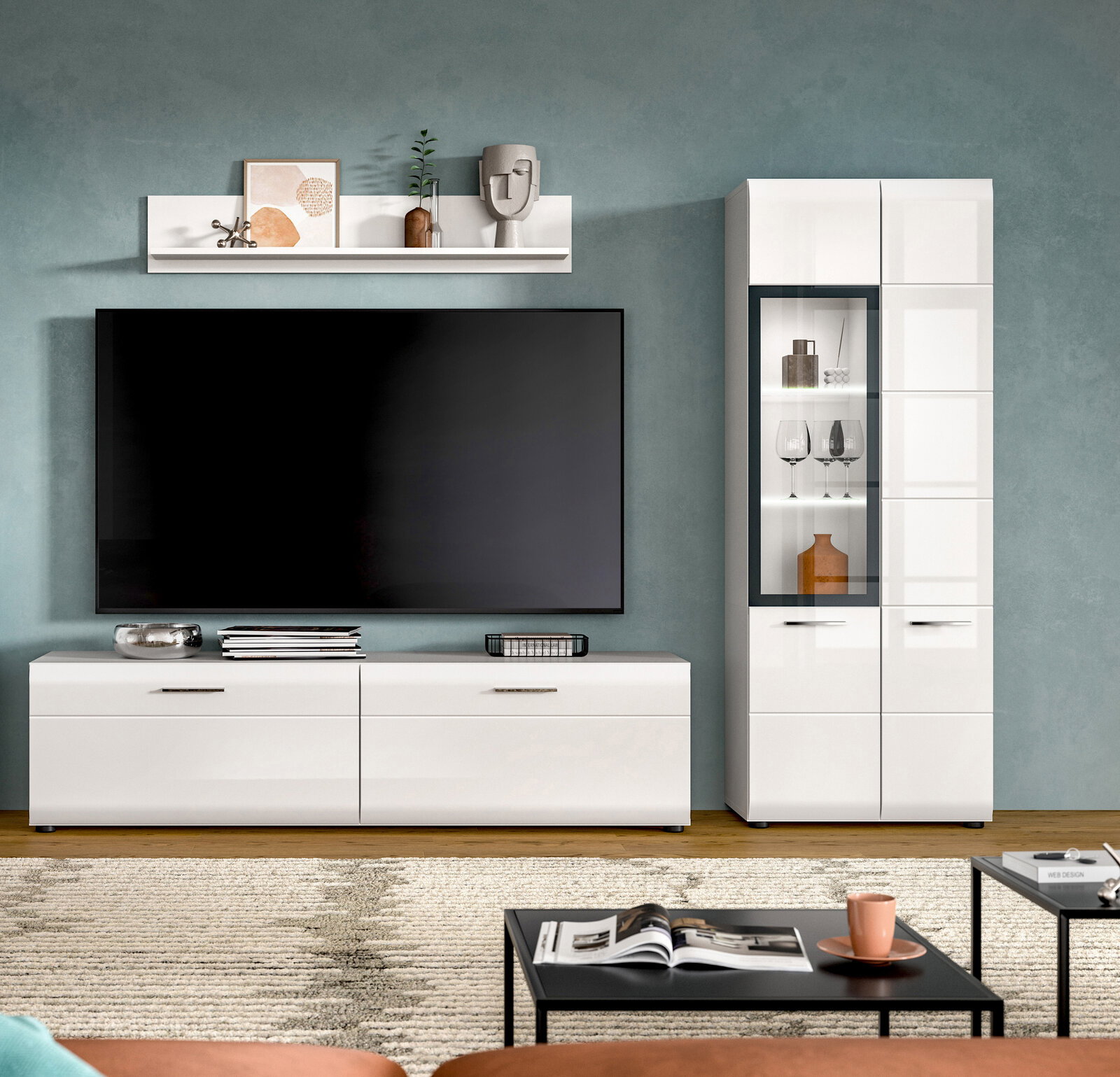 Modernes weißes TV-Lowboard mit großem Flachbildfernseher und passender Vitrine mit Glasfront im Wohnzimmer, frontal aus Augenhöhe fotografiert