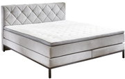 Boxspringbett in seitlicher Perspektive mit gestepptem Kopfteil und eleganten Metallfüßen