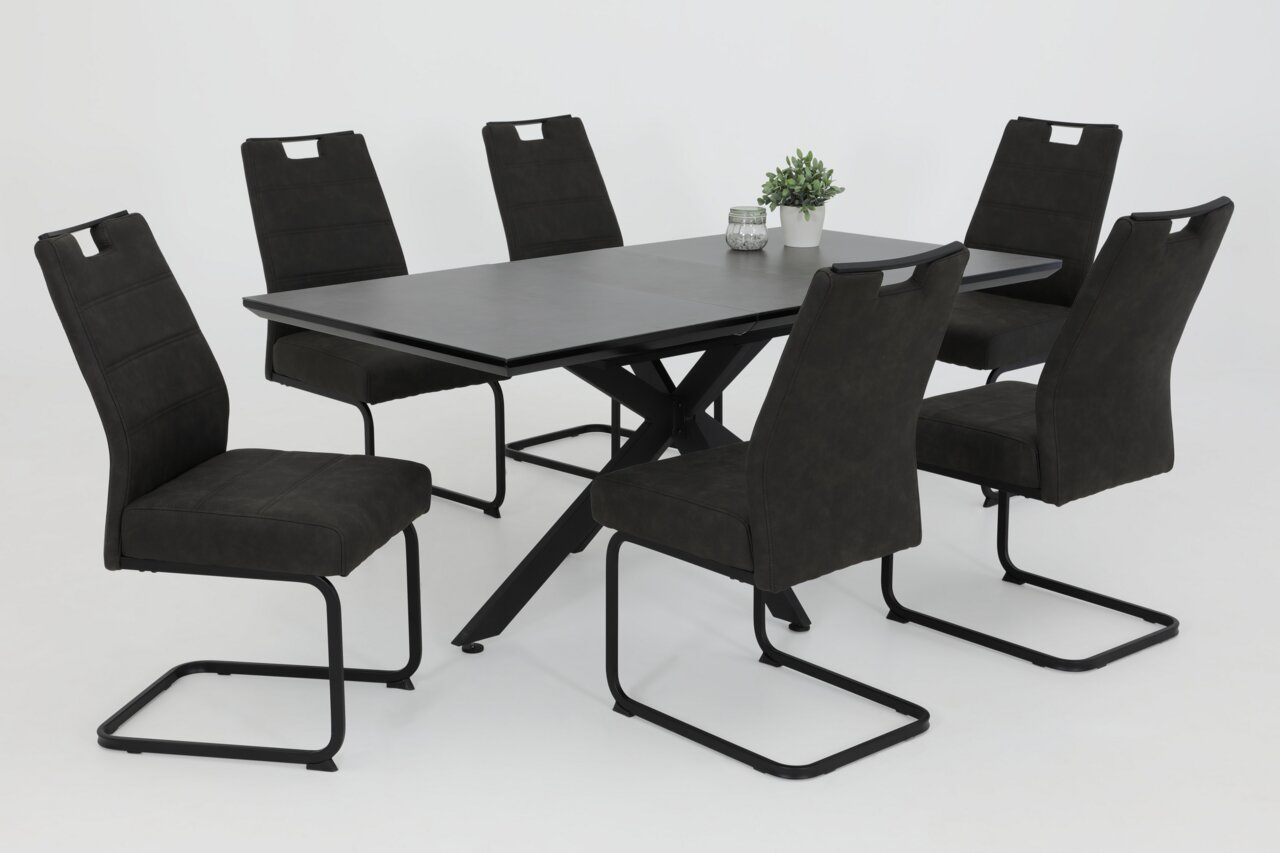 Sechs schwarze Schwingstühle um einen modernen schwarzen Tisch, seitliche Perspektive