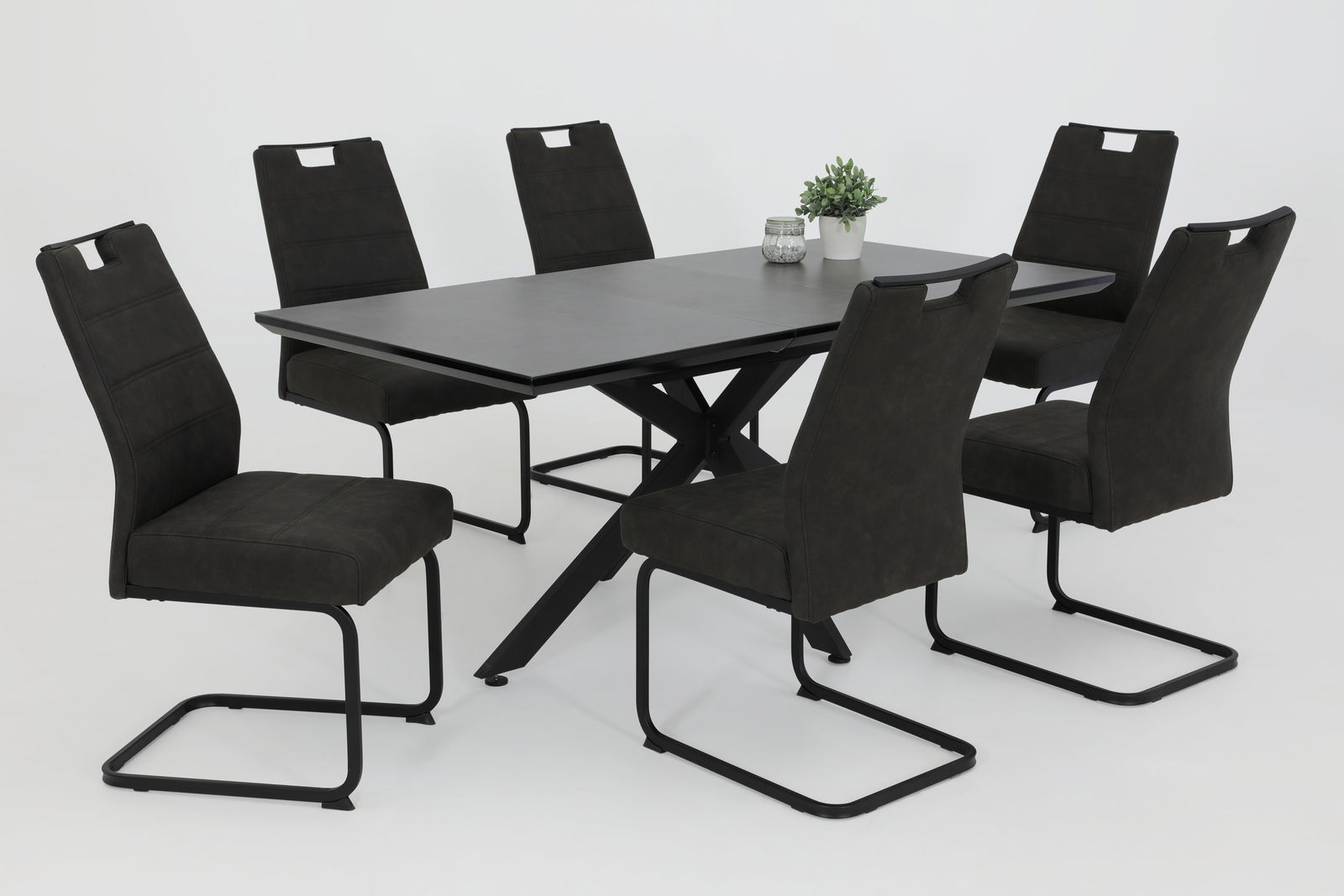 Sechs schwarze Schwingstühle um einen modernen schwarzen Tisch, seitliche Perspektive